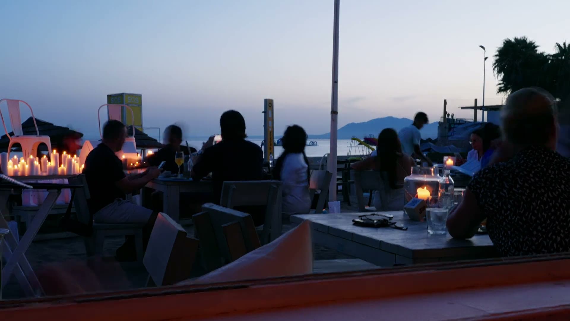 A candlelit dinner table beneath the evening sky
