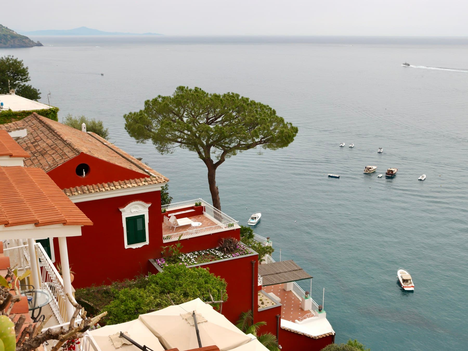 A red villa and umbrella pine above the sea